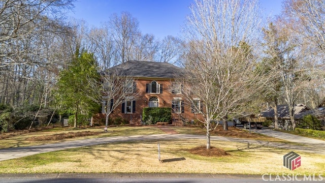 view of front of home with brick siding and a front lawn