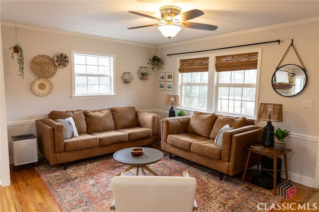 living room with baseboards, a ceiling fan, wood finished floors, and crown molding