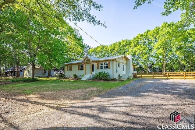 single story home with crawl space, gravel driveway, a front yard, and fence