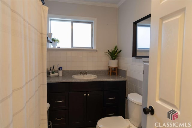 bathroom featuring vanity, tile walls, toilet, and crown molding