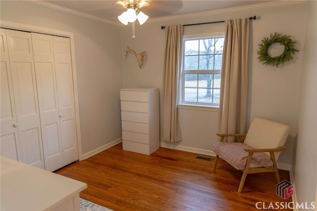 unfurnished room with visible vents, ornamental molding, baseboards, and wood finished floors