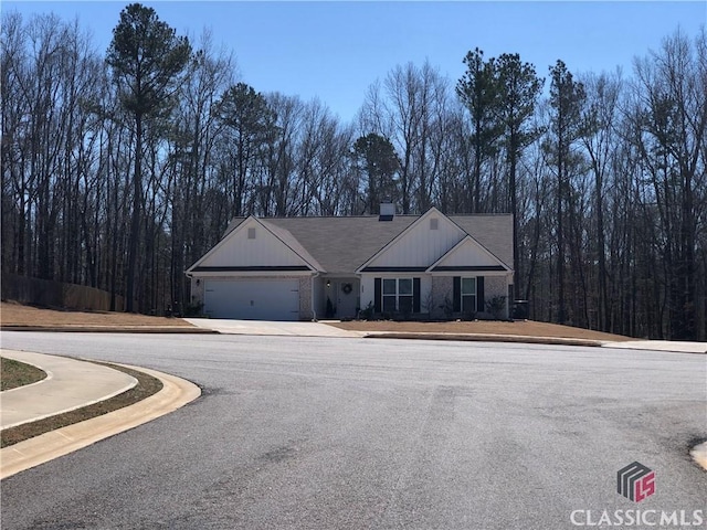 view of front of property with an attached garage, a chimney, and driveway