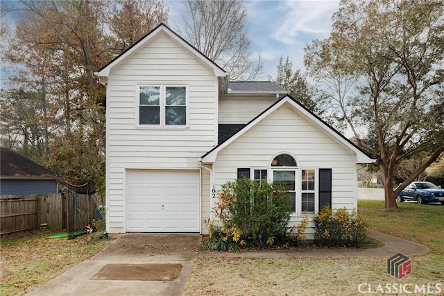 traditional-style house featuring a shingled roof, concrete driveway, a garage, and fence