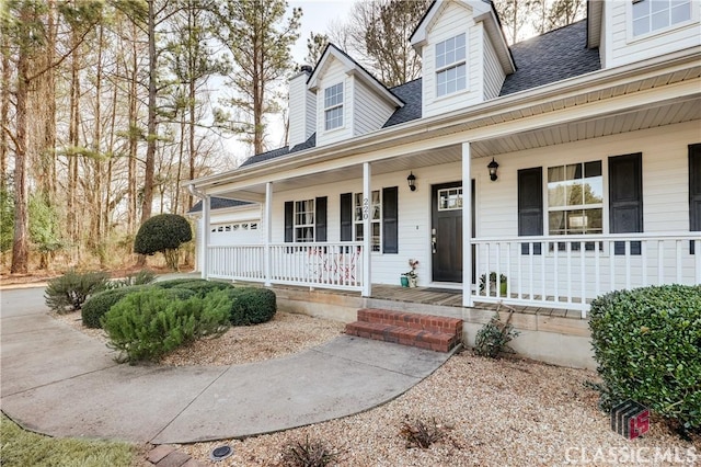 view of front of home featuring a porch, a shingled roof, and an attached garage