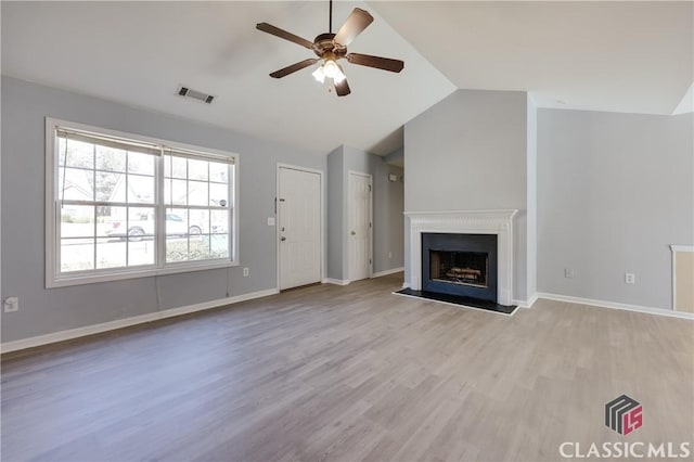 unfurnished living room with visible vents, wood finished floors, a fireplace, lofted ceiling, and ceiling fan