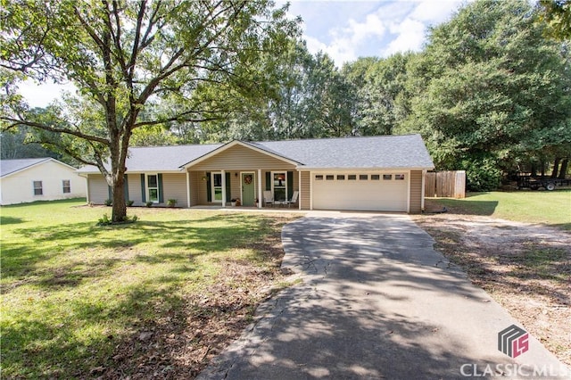 single story home featuring fence, a porch, a front yard, a garage, and driveway