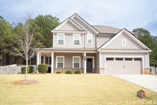 craftsman-style house featuring a garage, brick siding, board and batten siding, and driveway