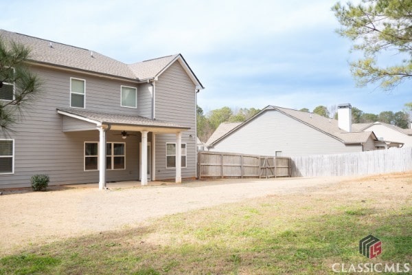 rear view of house featuring a patio, a yard, fence, and ceiling fan