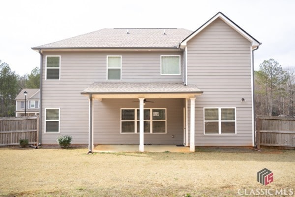 rear view of house with a lawn, a patio, ceiling fan, and fence