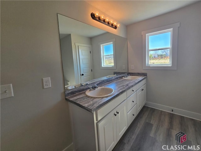 full bath featuring a sink, baseboards, and a wealth of natural light