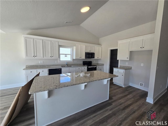 kitchen featuring a sink, visible vents, black appliances, and white cabinetry