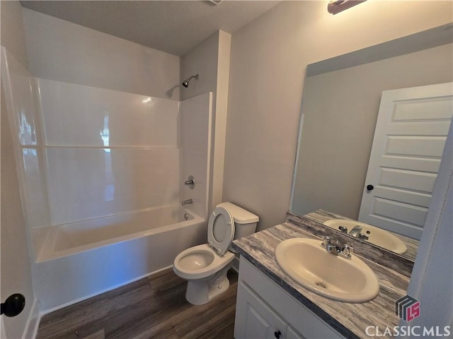 full bath with toilet, vanity, bathing tub / shower combination, and wood finished floors