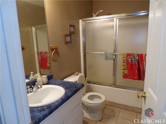 bathroom with tile patterned floors, toilet, shower / bath combination with glass door, and vanity