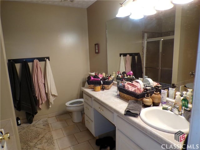 full bathroom with tile patterned floors, a shower stall, vanity, and toilet