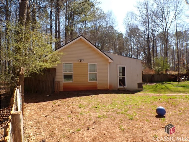 back of house featuring a yard and fence