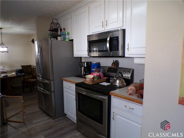 kitchen with white cabinets, stainless steel appliances, light countertops, and wood finished floors