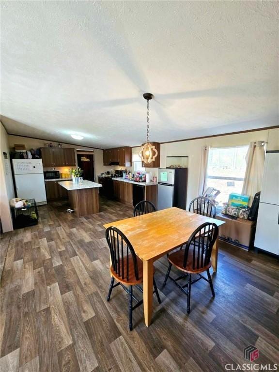 305 Langford Carey Rd, Danielsville, GA 30633 - dining space featuring dark wood finished floors, a textured ceiling, and a chandelier