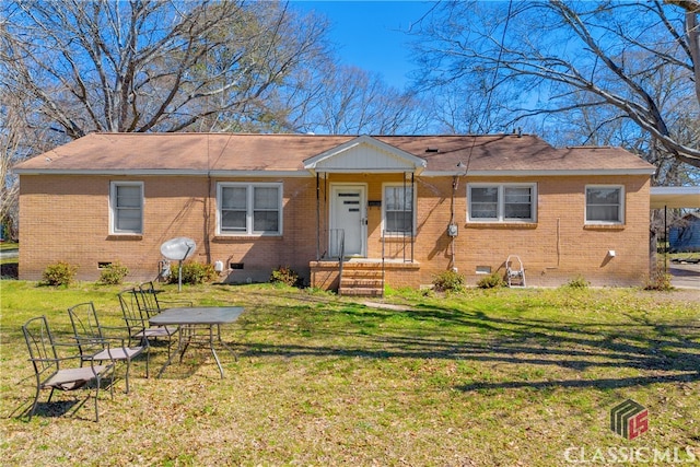 view of front of home featuring a carport, crawl space, brick siding, and a front lawn