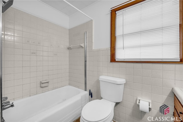 full bathroom featuring toilet, shower / tub combination, tile walls, wainscoting, and vanity