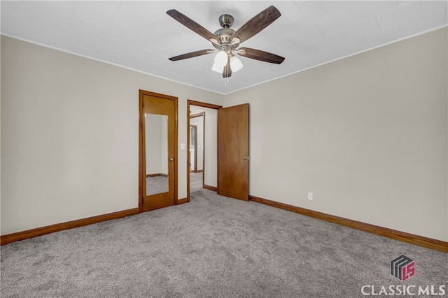 empty room featuring baseboards, carpet floors, and ceiling fan