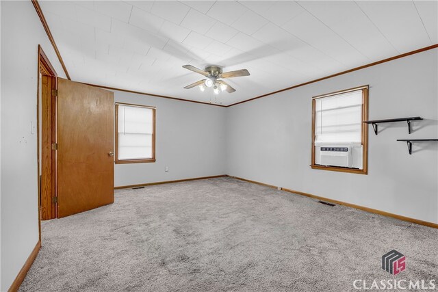 carpeted spare room with visible vents, cooling unit, crown molding, and baseboards