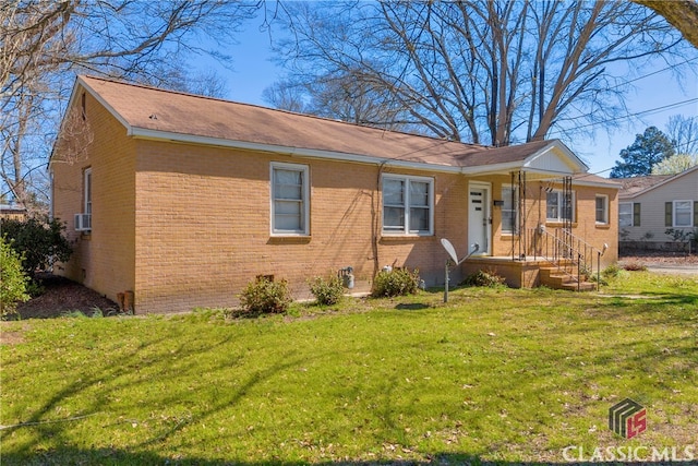 view of front of home featuring crawl space, brick siding, cooling unit, and a front lawn