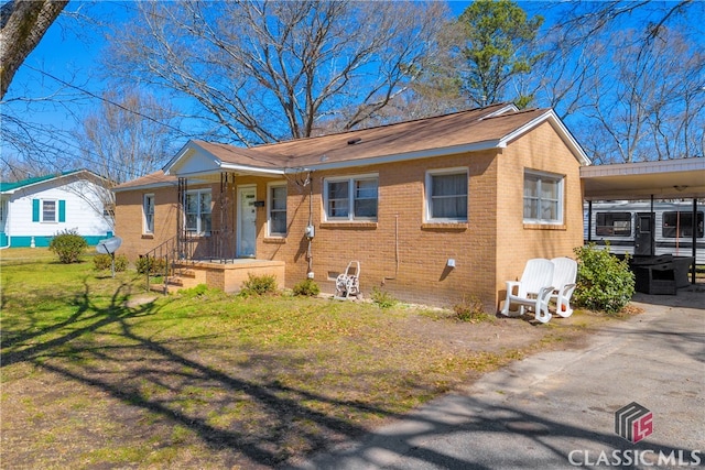 bungalow with brick siding, crawl space, an attached carport, and a front yard