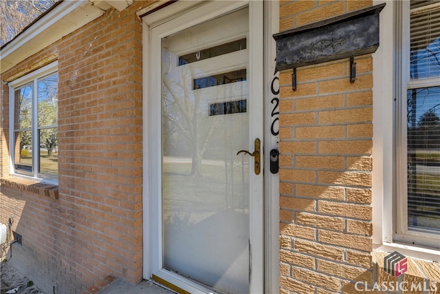 doorway to property with brick siding