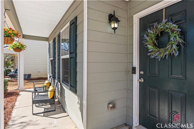 view of exterior entry featuring covered porch