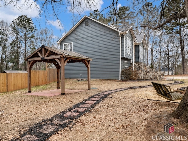 view of property exterior with a gazebo, fence, and a patio