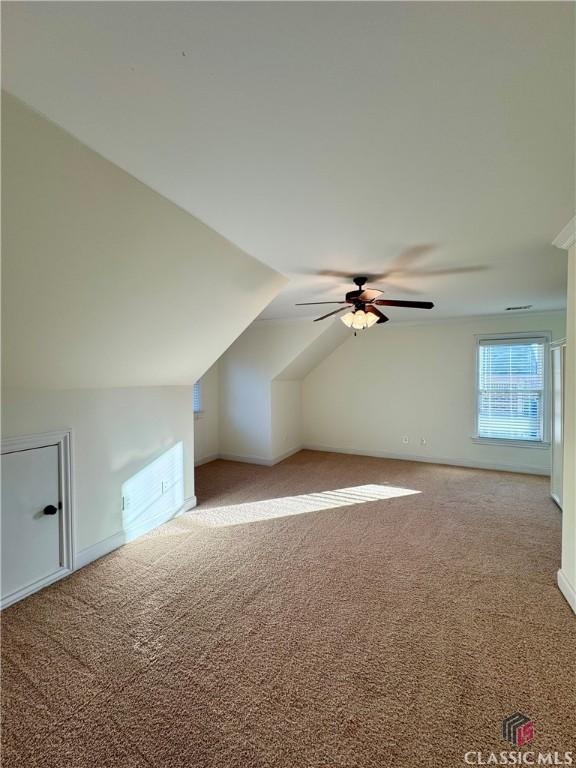 additional living space with lofted ceiling, carpet flooring, and ceiling fan