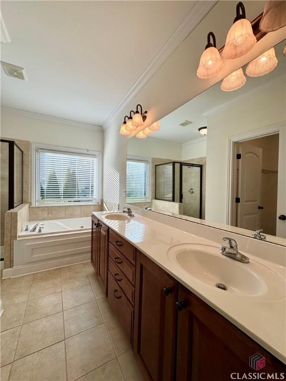 bathroom with tile patterned floors, a bath, a stall shower, and a sink