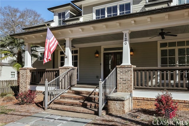 entrance to property with a porch, ceiling fan, and fence