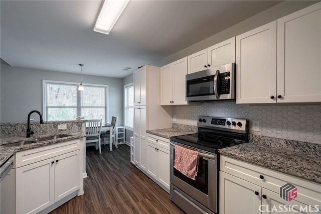 kitchen featuring a sink, stainless steel appliances, backsplash, and white cabinetry