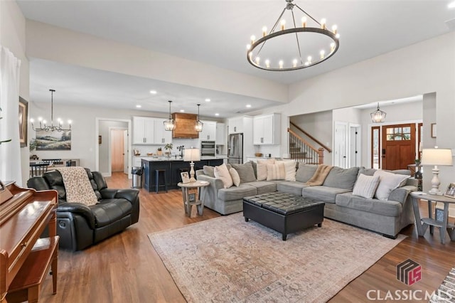 living room with a notable chandelier, recessed lighting, visible vents, and wood finished floors