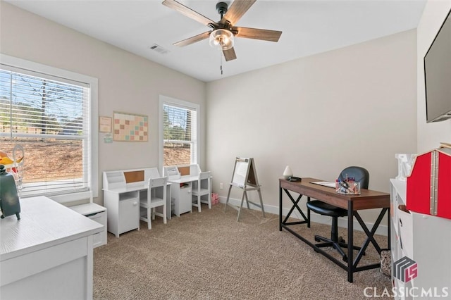 office area with baseboards, light colored carpet, visible vents, and ceiling fan