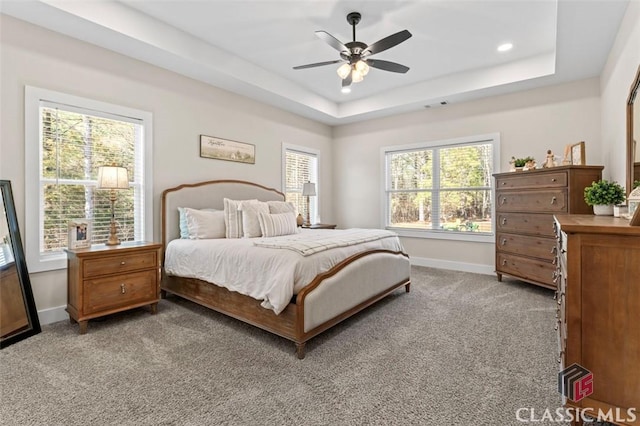 carpeted bedroom featuring recessed lighting, baseboards, and a tray ceiling