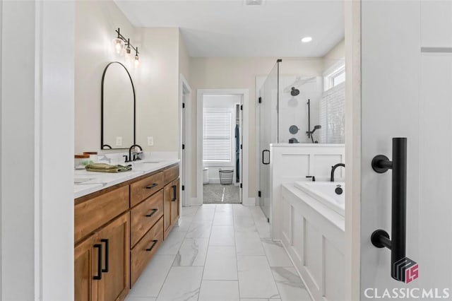 bathroom with vanity, a garden tub, marble finish floor, and a stall shower