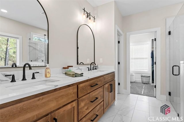 bathroom with double vanity, a shower stall, marble finish floor, and a sink