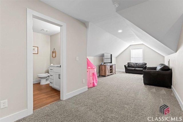 bedroom with visible vents, connected bathroom, baseboards, lofted ceiling, and carpet floors