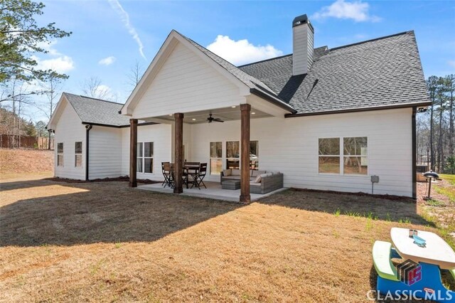 rear view of house with a shingled roof, a chimney, ceiling fan, a patio area, and an outdoor hangout area