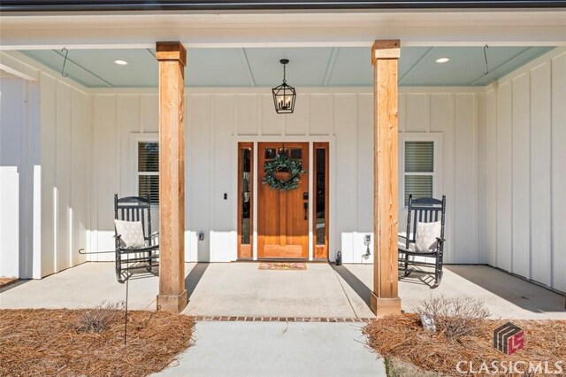 doorway to property featuring covered porch and board and batten siding