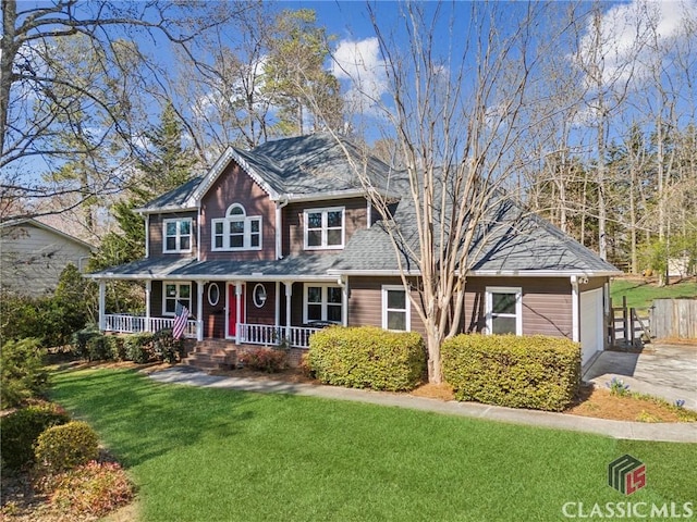 view of front of house featuring a front lawn, concrete driveway, covered porch, and an attached garage