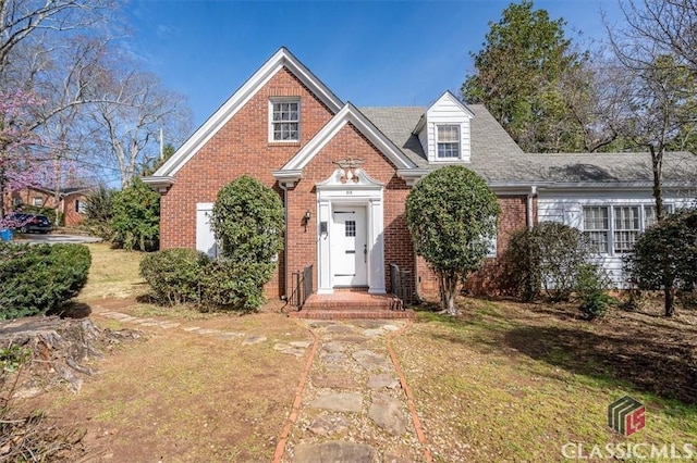 view of front of house featuring brick siding and a front lawn