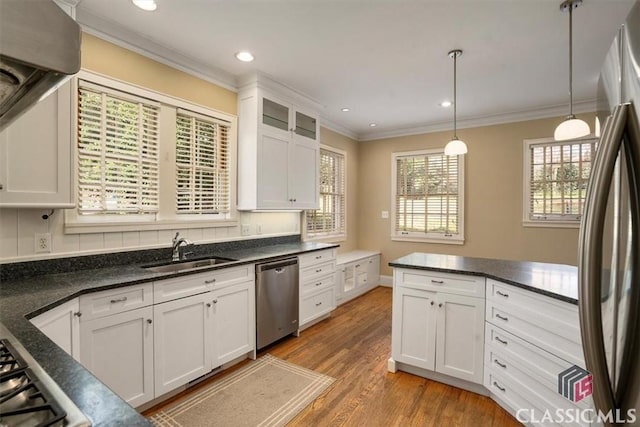 kitchen with ornamental molding, light wood-style flooring, a sink, stainless steel appliances, and white cabinets