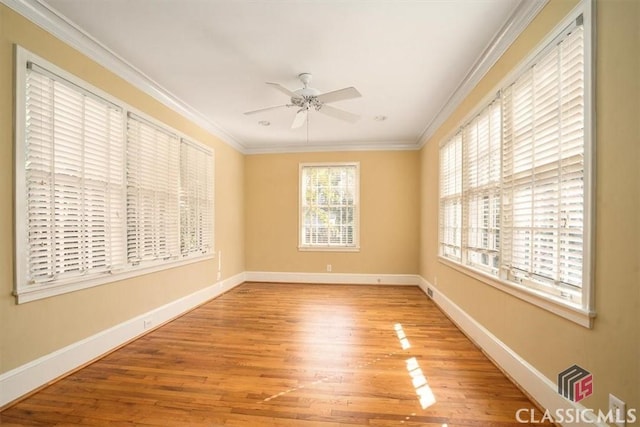 unfurnished room featuring ceiling fan, baseboards, wood finished floors, and crown molding