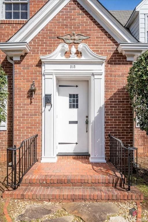 view of exterior entry featuring brick siding