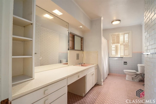 full bath featuring curtained shower, tile walls, a wainscoted wall, toilet, and vanity