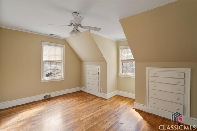 additional living space featuring visible vents, baseboards, lofted ceiling, and wood finished floors