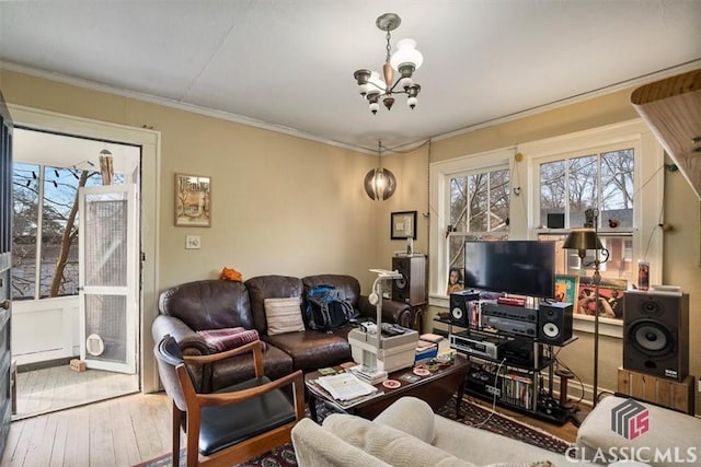 living area featuring a chandelier, hardwood / wood-style floors, and crown molding